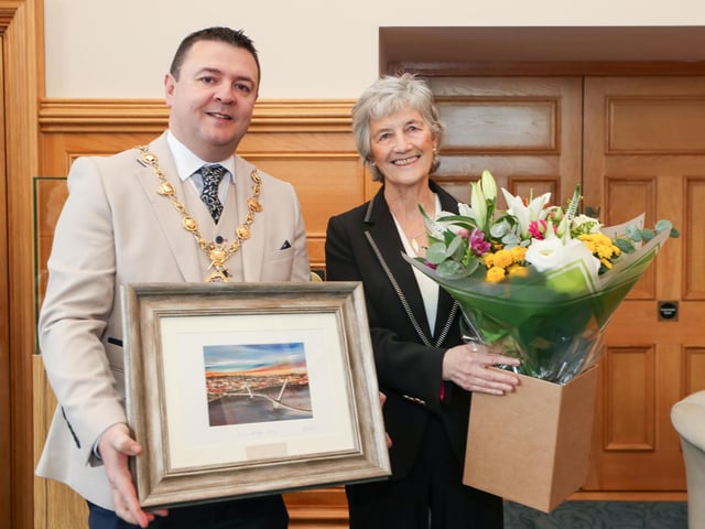Irish President Catherine Connolly receives a bouquet of flowers and Derry Peace Bridge print from the Mayor of Derry and Strabane Councillor Ruairí McHugh. Photo Lorcan Doherty