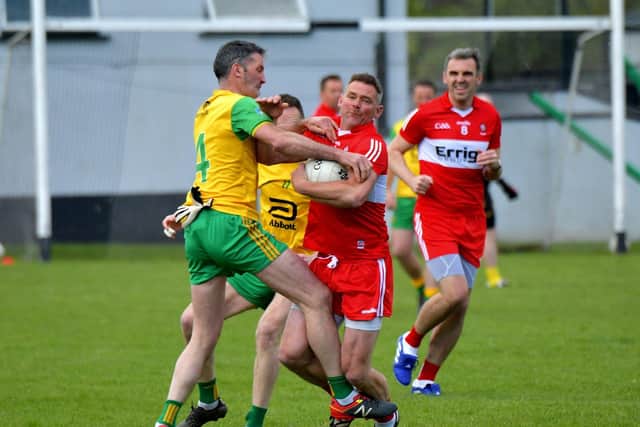The Derry Masters’ Brian Mullan keeps possession under pressure against Donegal Masters in the opening game.  Photo: George Sweeney. DER23118GS – 85