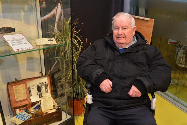 Former volunteer member of the Derry Corps of the Order of Malta Hugh Deehan, who was in the Bogside on Bloody Sunday. pictured pictured beside exhitits, including a photograph of himself at the Order of Malta Exhibition launch in the Museum of Free Derry on Monday evening last. Photo: George Sweeney. DER2305GS – 49