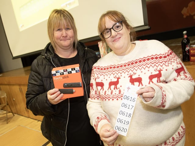 Martina Gallagher picks up her prize a 'Fire tv Stick' at the St. Joseph's Boys School Rickety Wheel from Lisa Grant.