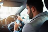 Using his phone while driving. (staged file pic)