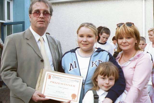 Richard Moore, Director of Children in Crossfire, pictured with Niamh Graham, a prizewinner in the writing competition. Also in photograph are Shauna and Linda Graham. 260603HG2
