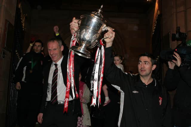 Team captain Peter Hutton and assistant boss Paul Hegarty hold up the FAI cup as Derry City arrive at Guildhall square in 2006.  LS49-543MT.