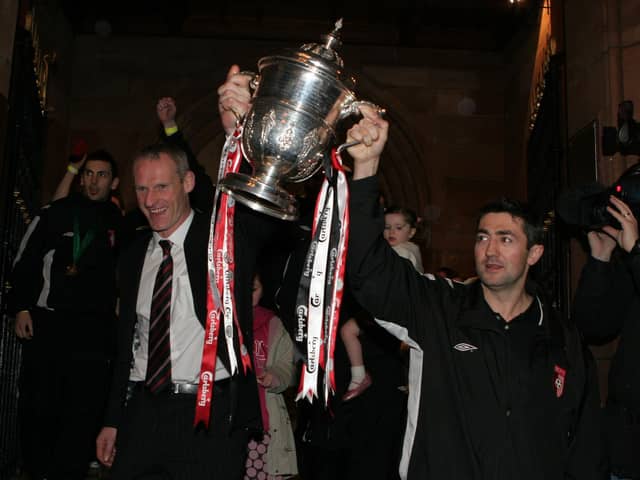 Team captain Peter Hutton and assistant boss Paul Hegarty hold up the FAI cup as Derry City arrive at Guildhall square in 2006.  LS49-543MT.
