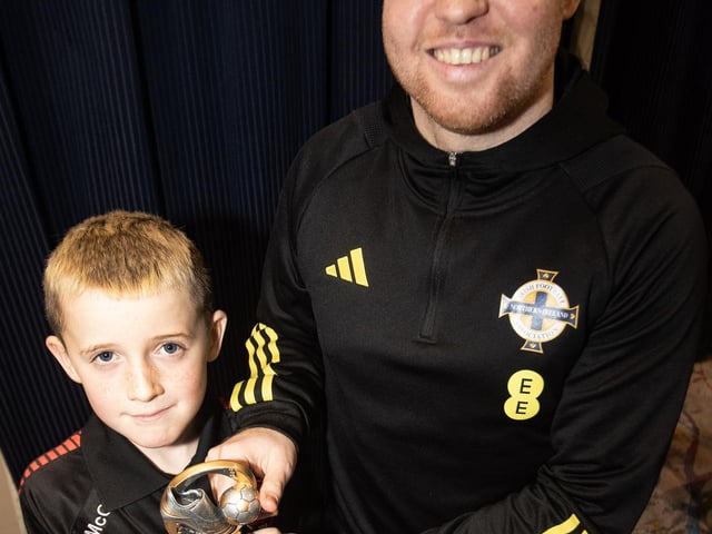 Young Logan McCourt, Phoenix FC receiving the U8s Player of the Year award from Ronan O'Donnell.