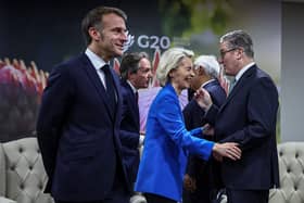 Britain's Prime Minister Keir Starmer (R) speaks to European Commission President Ursula Von der Leyen (C) as France's President Emmanuel Macron (L) looks on at the G20 Leaders' Summit at the Nasrec Expo Centre on November 22, 2025 in Johannesburg, South Africa. (Photo by Henry Nicholls-WPA Pool/Getty Images)
