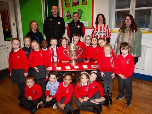 P2 pupils at St. Eugene’s PS show their support for Derry City on Monday last as players Shane McEleney and Joe Thompson brought the FAI Cup to the school.