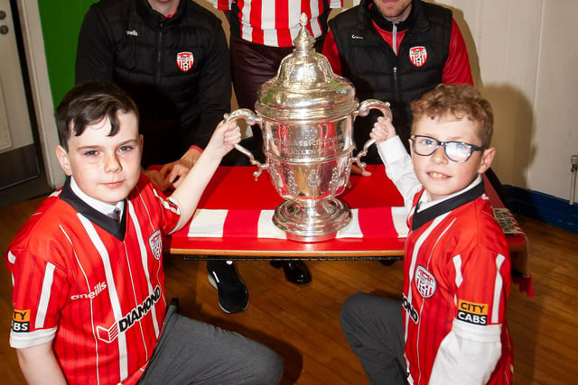 Caiden Saunders and Adam Burke, St. Eugene’s PS football team captains pictured with the FAI Cup on Monday morning. Included at back is Derry City players Shane McEleney and Joe Thompson and Mrs. Carol Duffy, school Principal. (Photos: Jim McCafferty Photography)