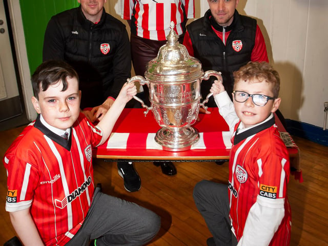 Caiden Saunders and Adam Burke, St. Eugene’s PS football team captains pictured with the FAI Cup on Monday morning. Included at back is Derry City players Shane McEleney and Joe Thompson and Mrs. Carol Duffy, school Principal. (Photos: Jim McCafferty Photography)