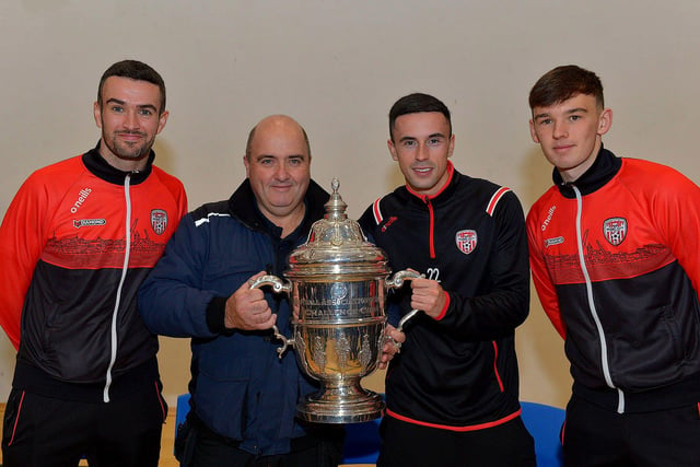 Derry City players Michael Duffy, Jordon McEneff and Liam Mullan, former pupils of St Columb's College, pictured with caretaker, Martin McKinney, during a visit to the school with the FAI Cup on Monday. Photo: George Sweeney. DER2247GS  32