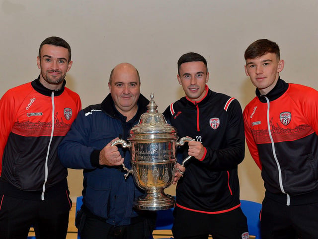 Derry City players Michael Duffy, Jordon McEneff and Liam Mullan, former pupils of St Columb's College, pictured with caretaker, Martin McKinney, during a visit to the school with the FAI Cup on Monday. Photo: George Sweeney. DER2247GS 32