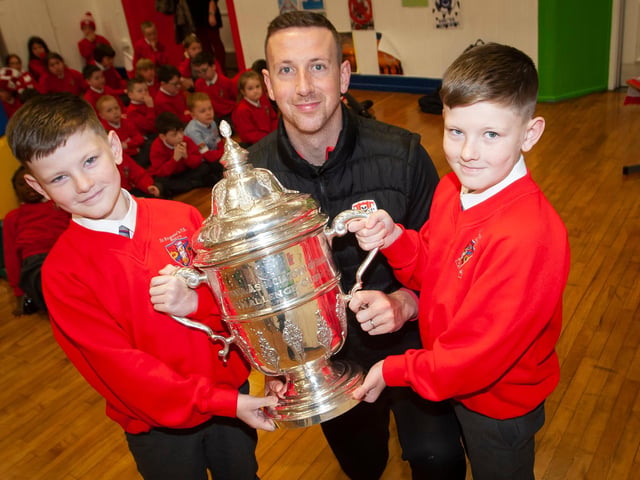 Twins Brandon and Tiernan Page pictured with Shane McEleney and the FAI Cup on Monday.