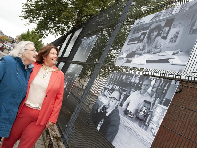 Well known community activist Mary Nelis pictured with the city and district's Mayor, Patricia Logue, looking at a photo of her 'younger self' in Friday's photo exhibition at Pilot's Row.