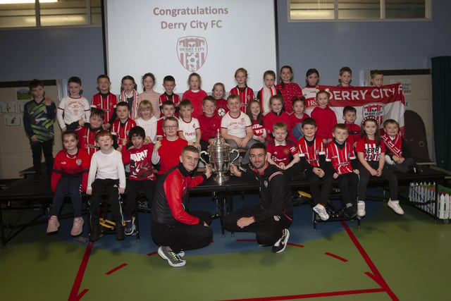 Derry players Caoimhin Porter and Michael Duffy and the FAI Cup pictured with the P3 classes at Greenhaw PS.