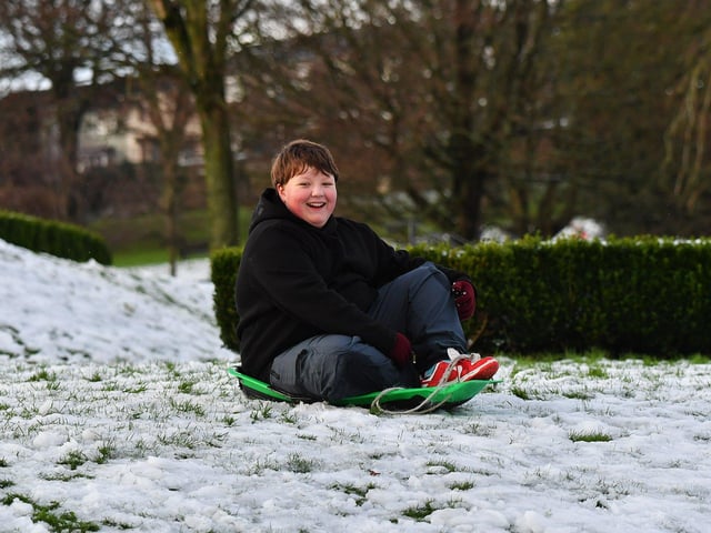 Children enjoy a day off school and a slide in the snow in Brooke Park on Thursday afternoon. Photo: George Sweeney