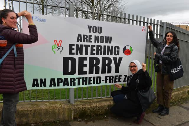 Nadya Tannous, left, Yasmine El Souda and Nihal El Ansar representing the Palestine Youth Movement launch a sign “You are now entering Derry an apartheid free zone” erected by the Bloody Sunday Trust, at the Junction of Letterkenny Road and Lone Moor Road, as part of this year’s Bloody Sunday anniversary events. Photo: George Sweeney