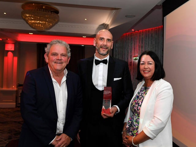 Community Champion of the Year Award winner Gary Rutherford receives his award from Apex Director of Housing Donna Matthewson and compere Adrian Logan. Photo: George Sweeney