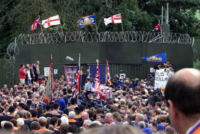 DRUMCREE, UNITED KINGDOM - JULY 9: Loyalist Orangemen hold their rally in front of the British military's blockade of the road past the Drumcree Parish Church in Drumcree 09 July 2000. The marchers went to the military blockade of the street leading to Garvaghy Road and did not pass into the adjoining Catholic neighbourhood. (ELECTRONIC IMAGE) (Photo credit should read JONATHAN UTZ/AFP via Getty Images)