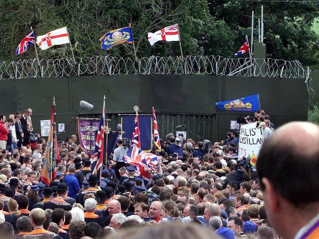 DRUMCREE, UNITED KINGDOM - JULY 9:  Loyalist Orangemen hold their rally in front of the British military's blockade of the road past the Drumcree Parish Church in Drumcree 09 July 2000. The marchers went to the military  blockade of the street leading to Garvaghy Road and did not pass into the adjoining Catholic neighbourhood.   (ELECTRONIC IMAGE)  (Photo credit should read JONATHAN UTZ/AFP via Getty Images)