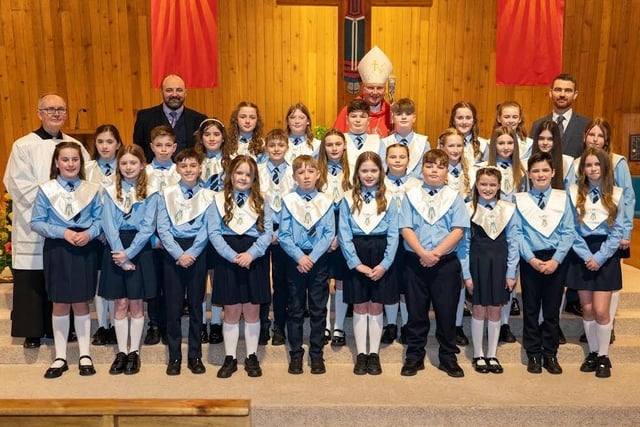 Pictured are pupils from Hollybush Primary School, who made their Confirmations recently. The pupils are pictured with staff and local clergy who officiated at the ceremony.
