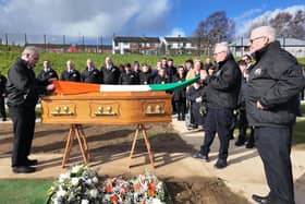 Gearóid Ó hEára, on left, with members of Tony Hassan's family and local republicans at the former councillor's graveside on Wednesday.