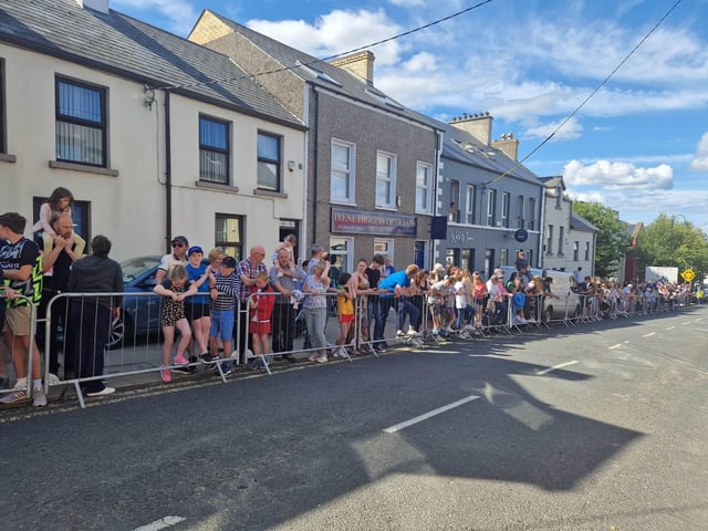 Members of the public wait near the finishing line.