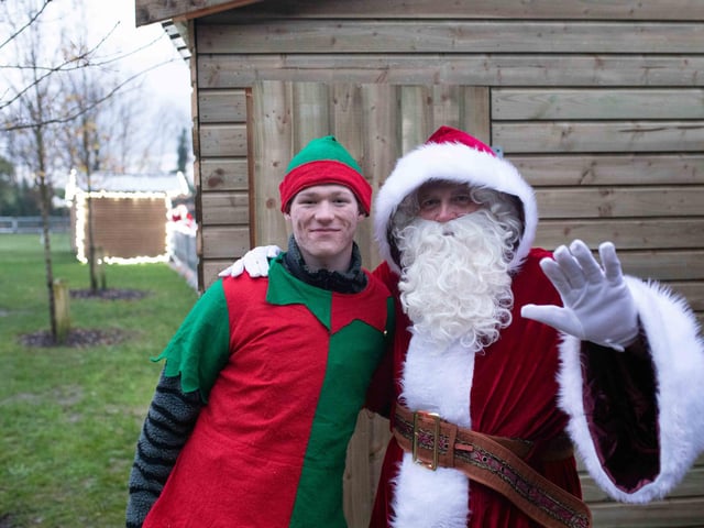 A wave from Santa and his elf.