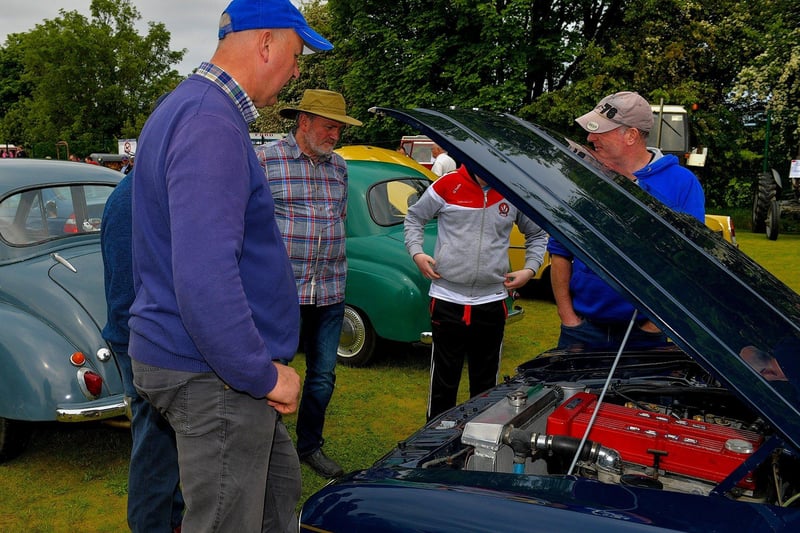 Enthusiasts admire a classic car engine at the Muff Vintage Show held in the Community Park on Sunday. Photo: George Sweeney. DER2321GS – 16