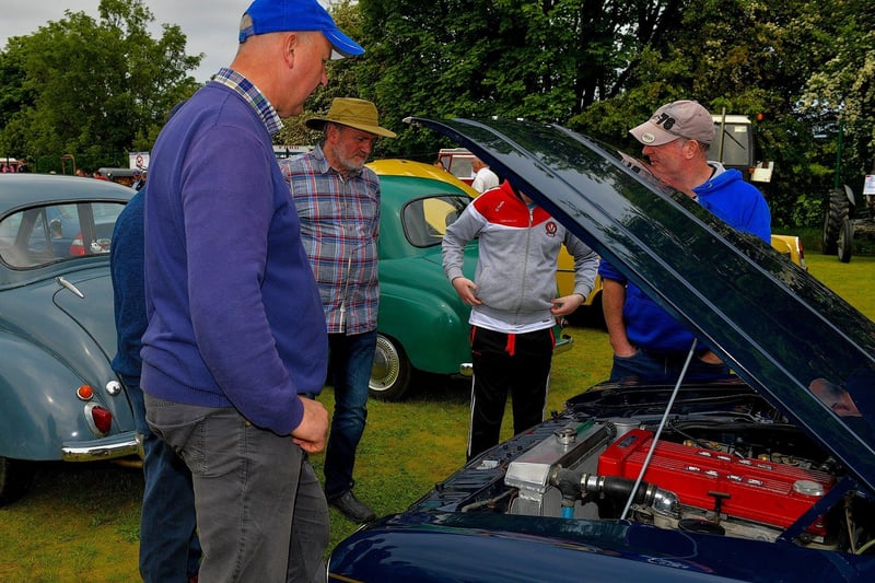 Enthusiasts admire a classic car engine at the Muff Vintage Show held in the Community Park on Sunday. Photo: George Sweeney.  DER2321GS – 16 
