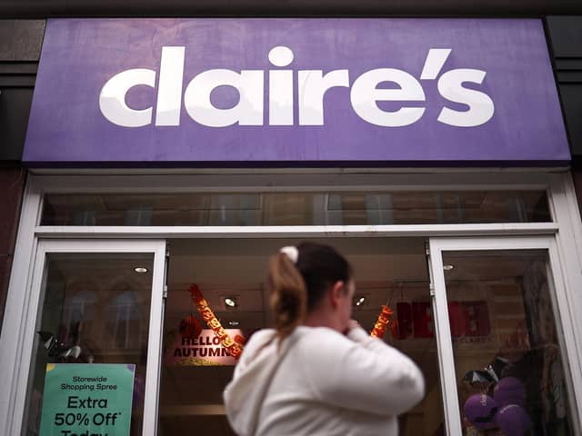 Members of the public walk past a branch of "Claire's". (Photo by HENRY NICHOLLS/AFP via Getty Images)