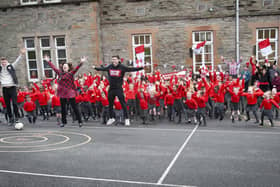WHO'S UP FOR THE CUP? Derry City players Cameron McJannet and Declan Glass pictured with the pupils of St Eugene's PS who can't wait for Sunday's FAI Cup Final.