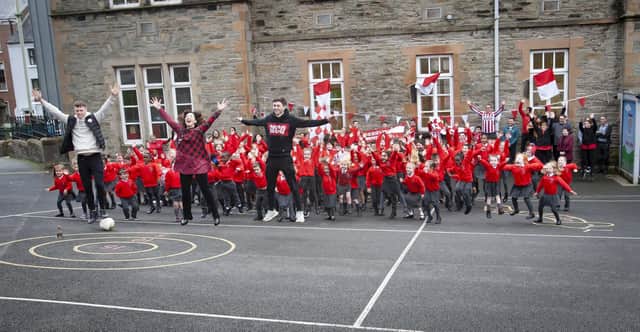 WHO'S UP FOR THE CUP? Derry City players Cameron McJannet and Declan Glass pictured with the pupils of St Eugene's PS who can't wait for Sunday's FAI Cup Final.