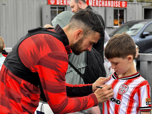 Michael Duffy signs a shirt for a fan at the Derry City open training session on Monday morning in  Brandywell Stadium. The event was organised at part of the Gasyard Feile.  Photo: George Sweeney / Derry Journal