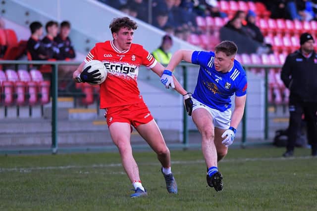 Derry’s Danny McDermott holds off a tackle from Oliver McCrystal of Cavan. Photo: George Sweeney