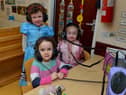 Ava, Olivia and Esne listen to an audio book on World Book Day at Belmont Nursery School on Racecourse Road. Photo: George Sweeney. DER2310GS – 26