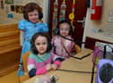 Ava, Olivia and Esne listen to an audio book on World Book Day at Belmont Nursery School on Racecourse Road. Photo: George Sweeney. DER2310GS – 26