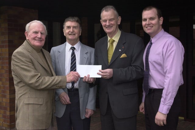 Foyle Hospice Founder Dr Tom McGinley with others during a cheque presentation.