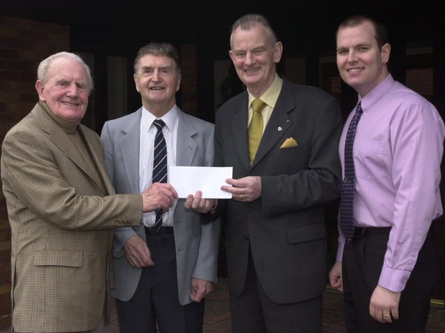 Foyle Hospice Founder Dr Tom McGinley with others during a cheque presentation.