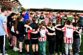Derry City captain Mark Connolly, Michael Duffy and Ciaron Harkin join in a huddle with some of the guests representing the HSC NI Fostering Service before Friday night's match.
