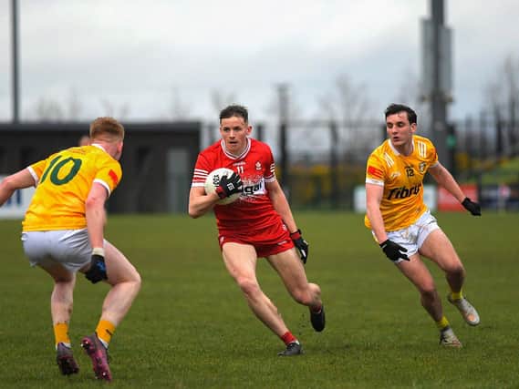 Antrim pair Conniaodh McCann and Callum Walsh close in on Derry’s Ruairi Forbes. Photo: George Sweeney