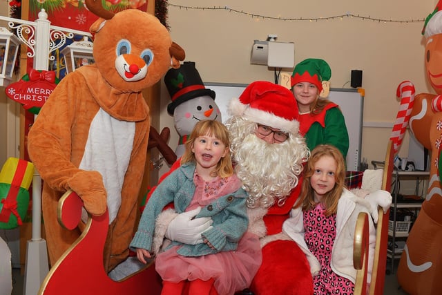 Carragh and Clodagh pictured with Santa and his helpers at the Galliagh Community Christmas Craft Fair and Wonderland on Saturday afternoon.  Photo: George Sweeney