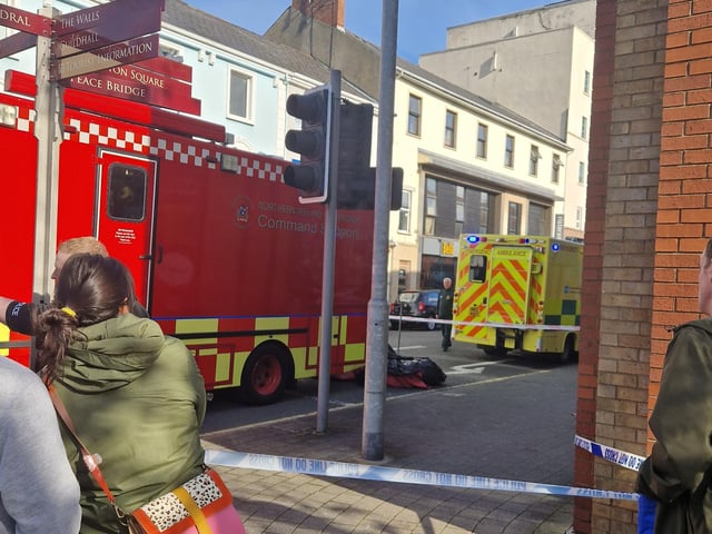 Bystanders look on as emergency services deal with the fire.