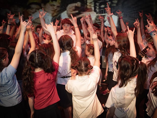 James McFaul and P6/7 pupils rock it out on stage as they perform Stick it to the Man from School of Rock!
