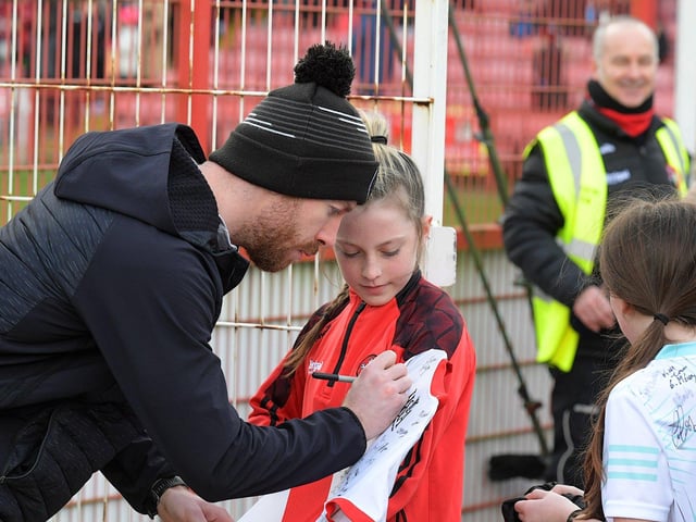 Niall Loughlin signs a shirt for a young fan before the Derry v Dublin game on Saturday. Photo: George Sweeney