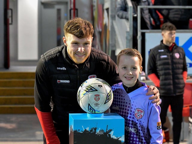 A young fan has his picture taken with Cameron McJannett before Derry City’s game against Cork City on Friday evening. Photo: George Sweeney. DER2308GS – 141