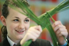 A girl fashioning a St. Brigid's Cross.