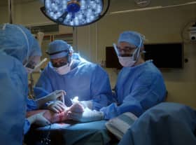 Surgeons performing operation on injured leg