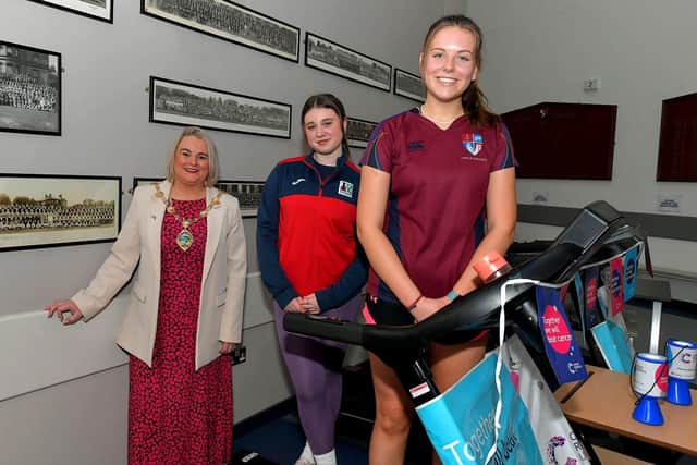 Student Katie McArthur, Lisneal College, and Megan Cairns, Foyle College, pictured with Mayor Sandra Duffy during  a break in their treadmill marathon in aid of Cancer Research UK, at the school on Wednesday morning. Photo: George Sweeney. DER2308GS – 95