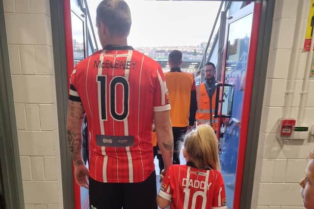 Patrick McEleney and his daughter Saorlaith walk out onto the Brandywell pitch.