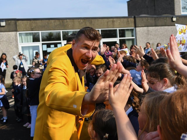 Ian Clarkson of the Jive Aces greets pupils at Rosemount Primary School on Thursday morning. Photo: George Sweeney